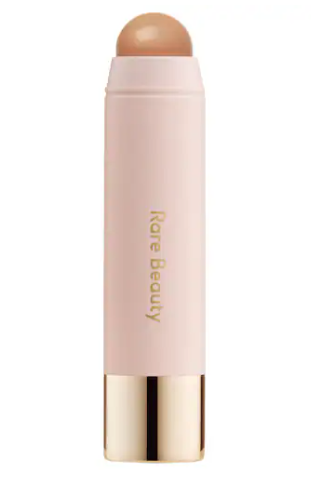 Rare Beauty by Selena Gomez - Warm Wishes Effortless Cream Bronzer Stick, un innovador bronceador en crema en barra para lograr un brillo bronceado rápido y visible con un acabado suave y uniforme